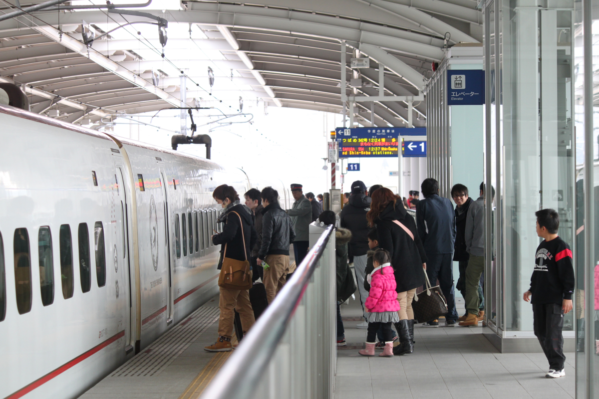 駅に停まっている新幹線に人々が乗り込もうとしている様子